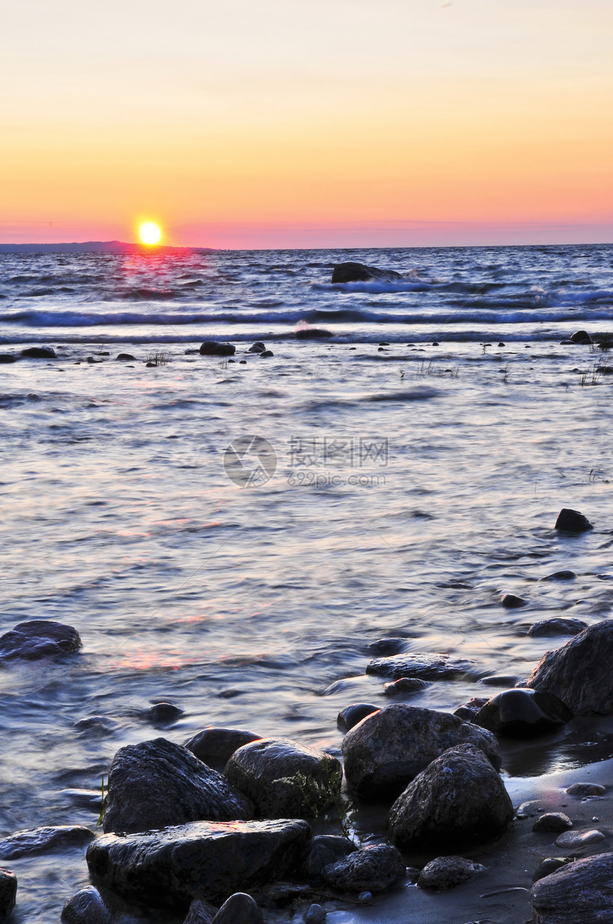 日落在水上石头风景岩石海洋天空湖岸海滩反射海岸线公园图片