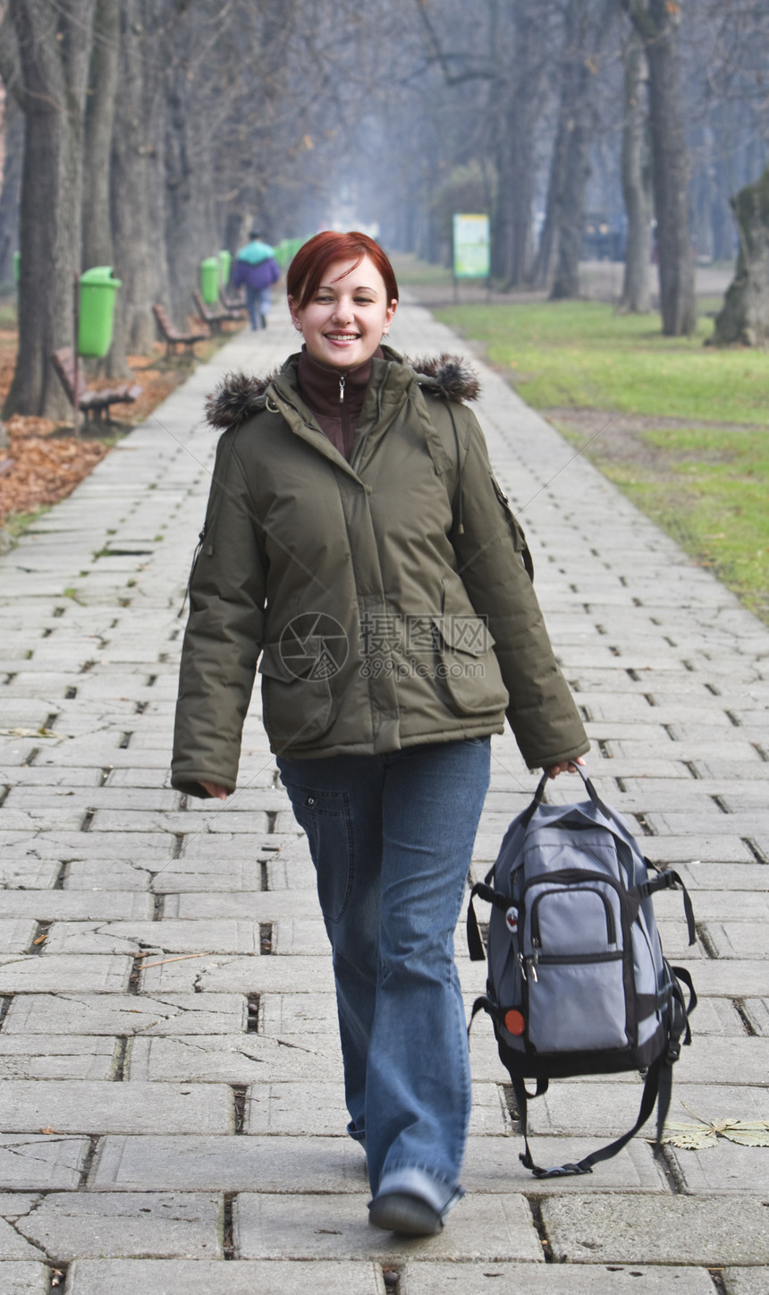 在秋天公园散步红发青少年女士牛仔裤风衣女性化路面女孩女性夹克图片
