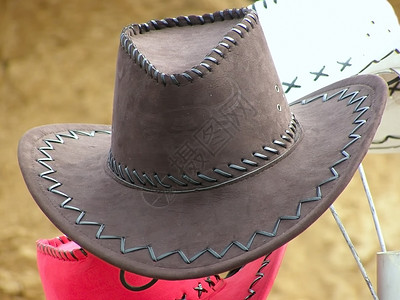 牛仔帽子水牛衣服表演棕色服装皮革编织背景图片