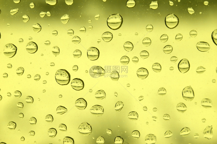 玻璃上的雨滴液体黄色气泡珠子反射图片