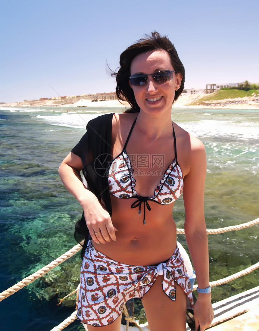 女人在度假时享受阳光微笑女孩们成人海滩闲暇头发天空女性假期自由图片