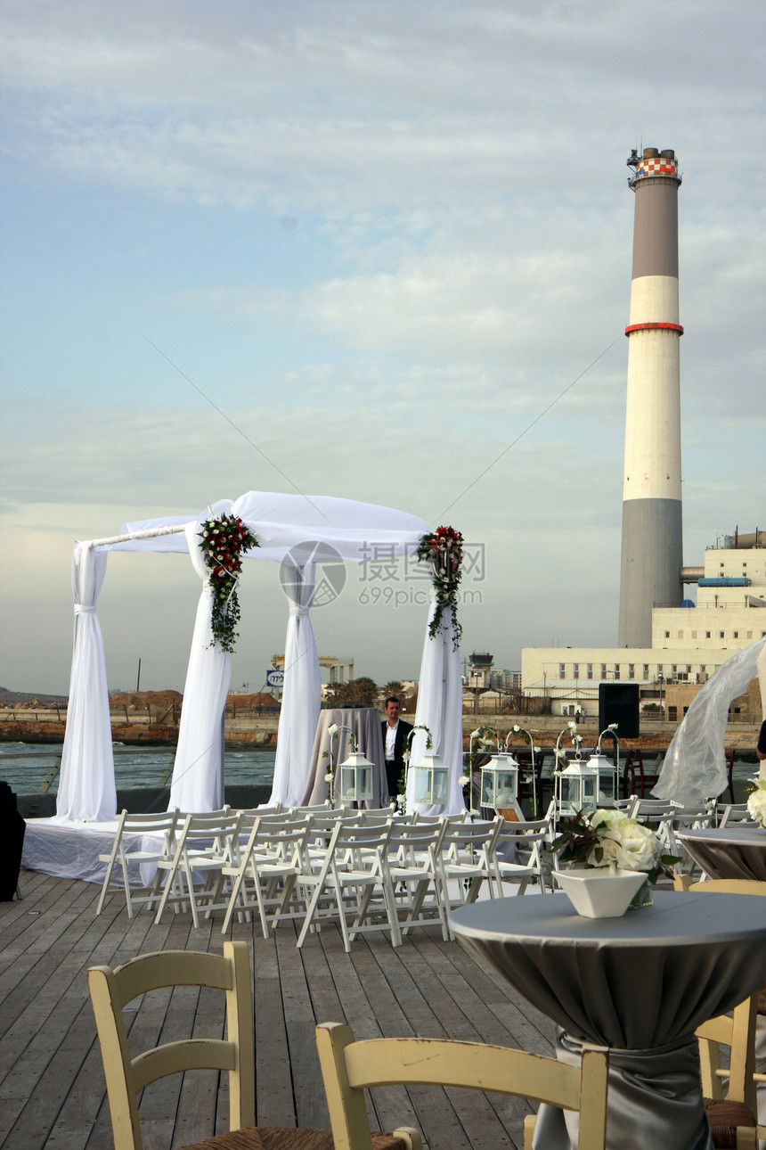 在海滨有工业观望的Chuppah港口木头火锅地面花朵婚礼城市传统图片