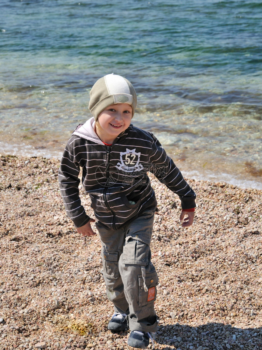 小金发男孩在海滩上玩得很开心图片