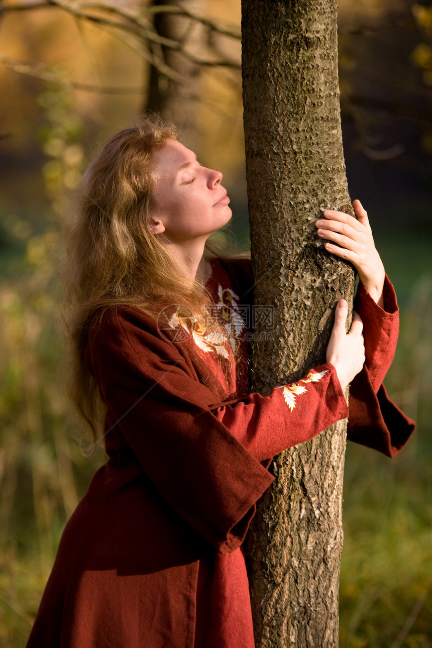 秋林中的精灵女性森林裙子拥抱戏服小精灵故事神话树干头发图片