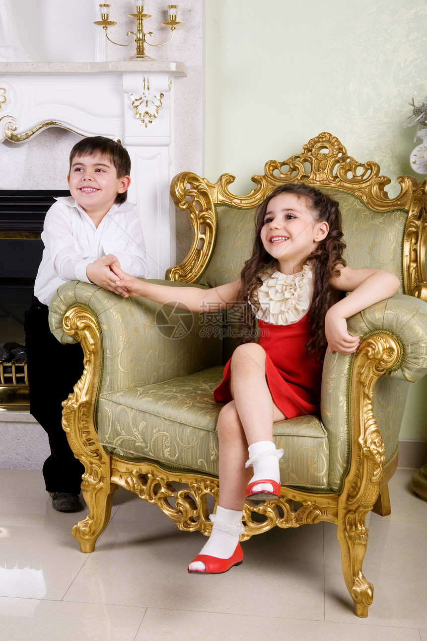 女孩和男孩在房间里朋友们姐姐童年兄弟座位家具扶手椅乐趣裙子装饰品图片