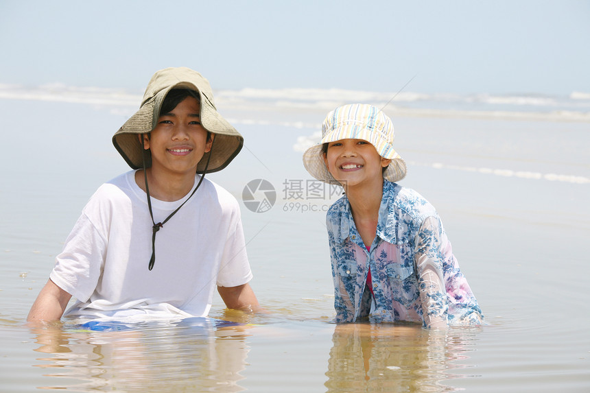 两名儿童在海洋岸边的水中生活图片