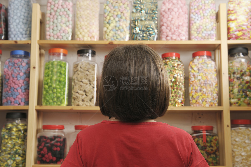 儿童在糖果店选择罐子集装箱少年孩子童年货架店铺青年孩子们图片