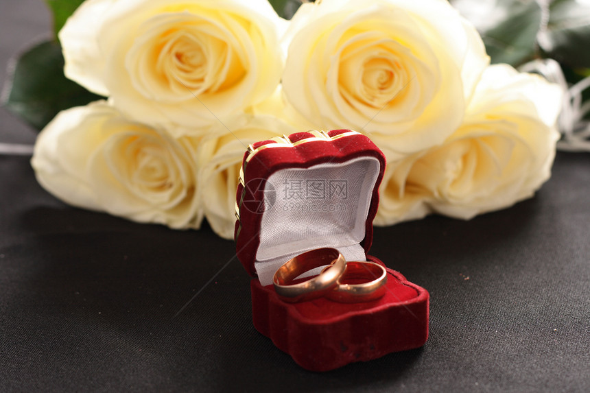 圆环和玫瑰女性植物金属婚姻宝藏红色婚礼仪式花瓣黑色图片