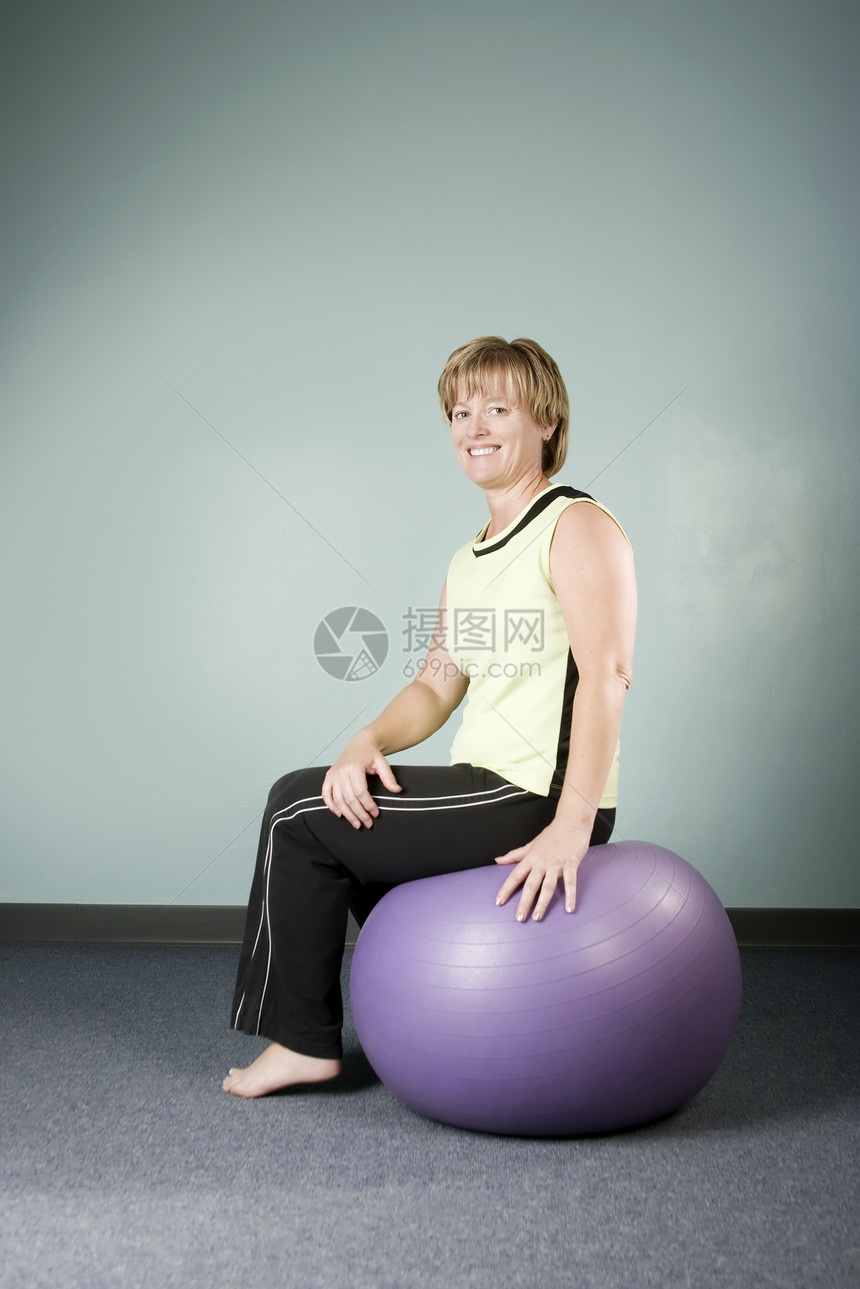 坐在运动舞会上的妇女金发女郎灵活性肌肉健身物理编辑女性健身房力量身体修剪图片