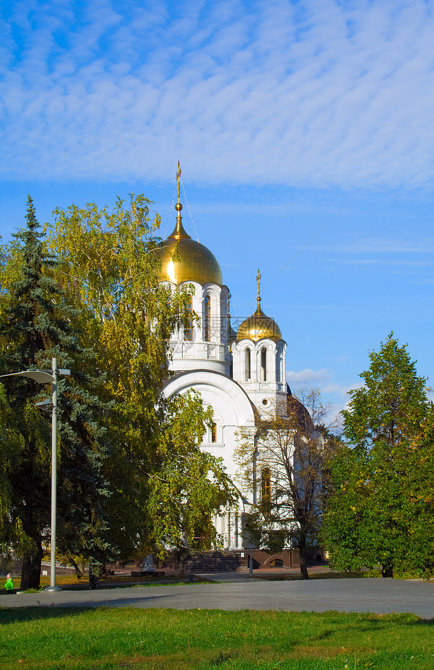 东正教教堂在黄树中转动图片