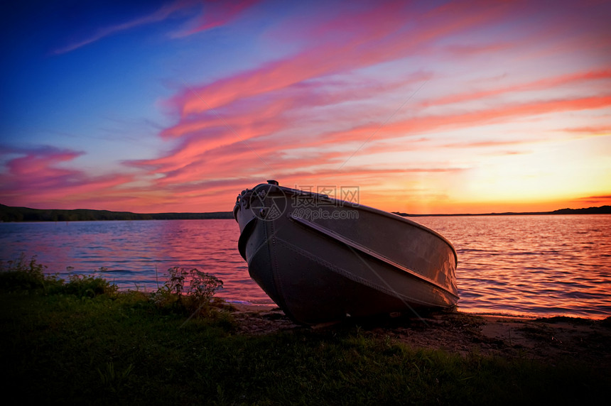 日落时湖岸渔船的图象图片