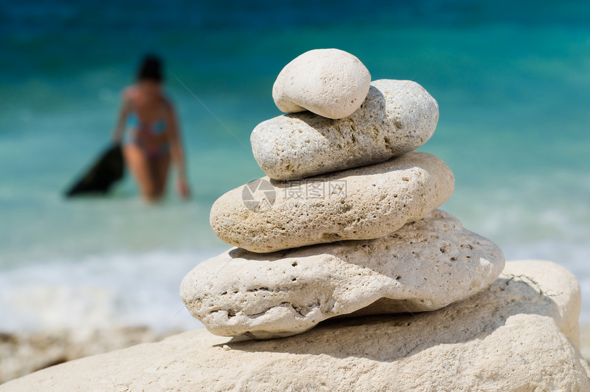 海滩上堆叠的石块旅行蓝色石灰石海岸女性装饰晴天平衡岩石支撑图片
