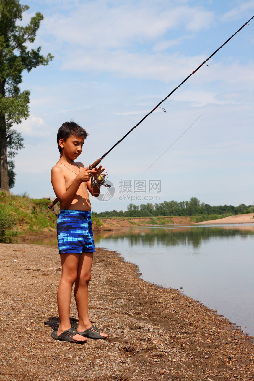 男孩通过旋转钓鱼场景享受海滩男生乐趣蓝色爱好青年渔夫闲暇图片