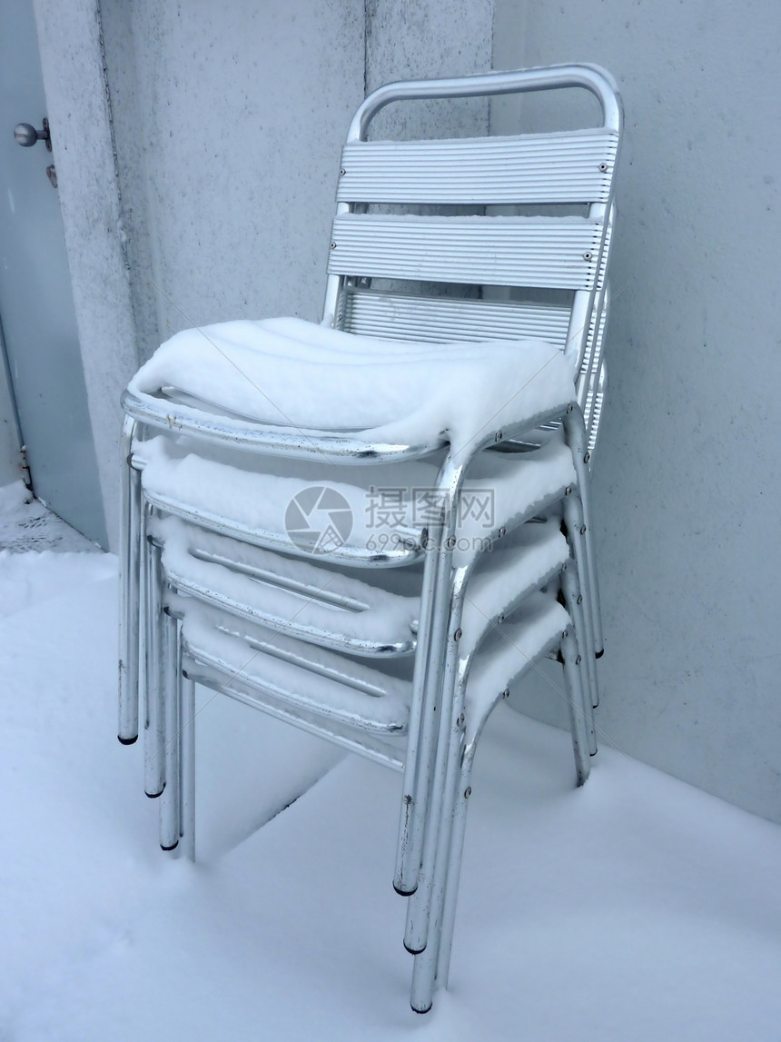 雪雪覆盖的椅子堆图片