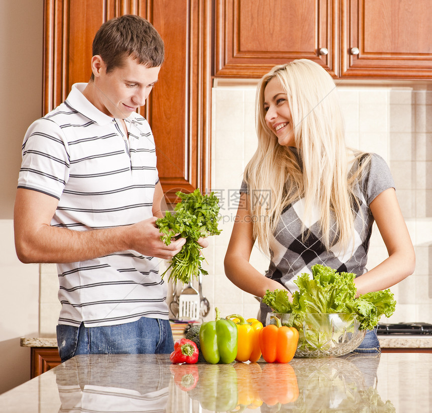 青年夫妇制作沙律正方形蔬菜胡椒台面男人女士柜台头发玻璃女性图片
