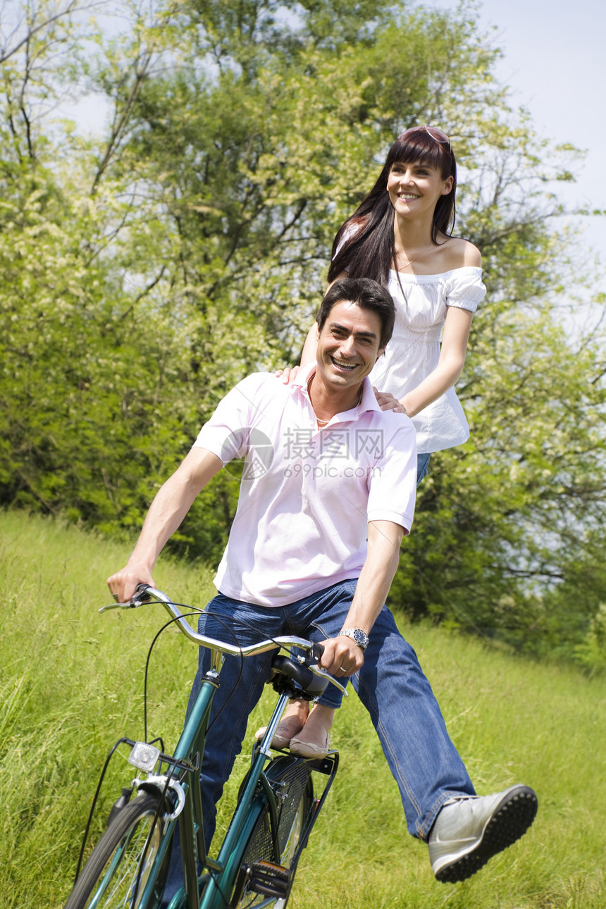 草地公园女士男朋友年轻人活动自行车微笑拥抱夫妻女朋友图片