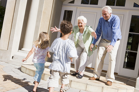 祖父母欢迎孙辈人人员夫妻孙女退休男生兄弟访问祖母女孩前门背景图片
