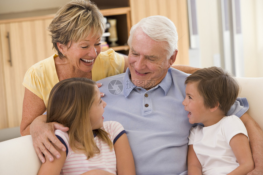 祖父母与孙子女一起笑沙发客厅拥抱兄弟祖母家庭女孩女士亲密感小男孩图片