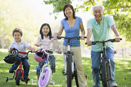 与孙辈一起骑自行车的祖父母成人公园男性女士农村女性小男孩婴儿潮男人家庭背景图片