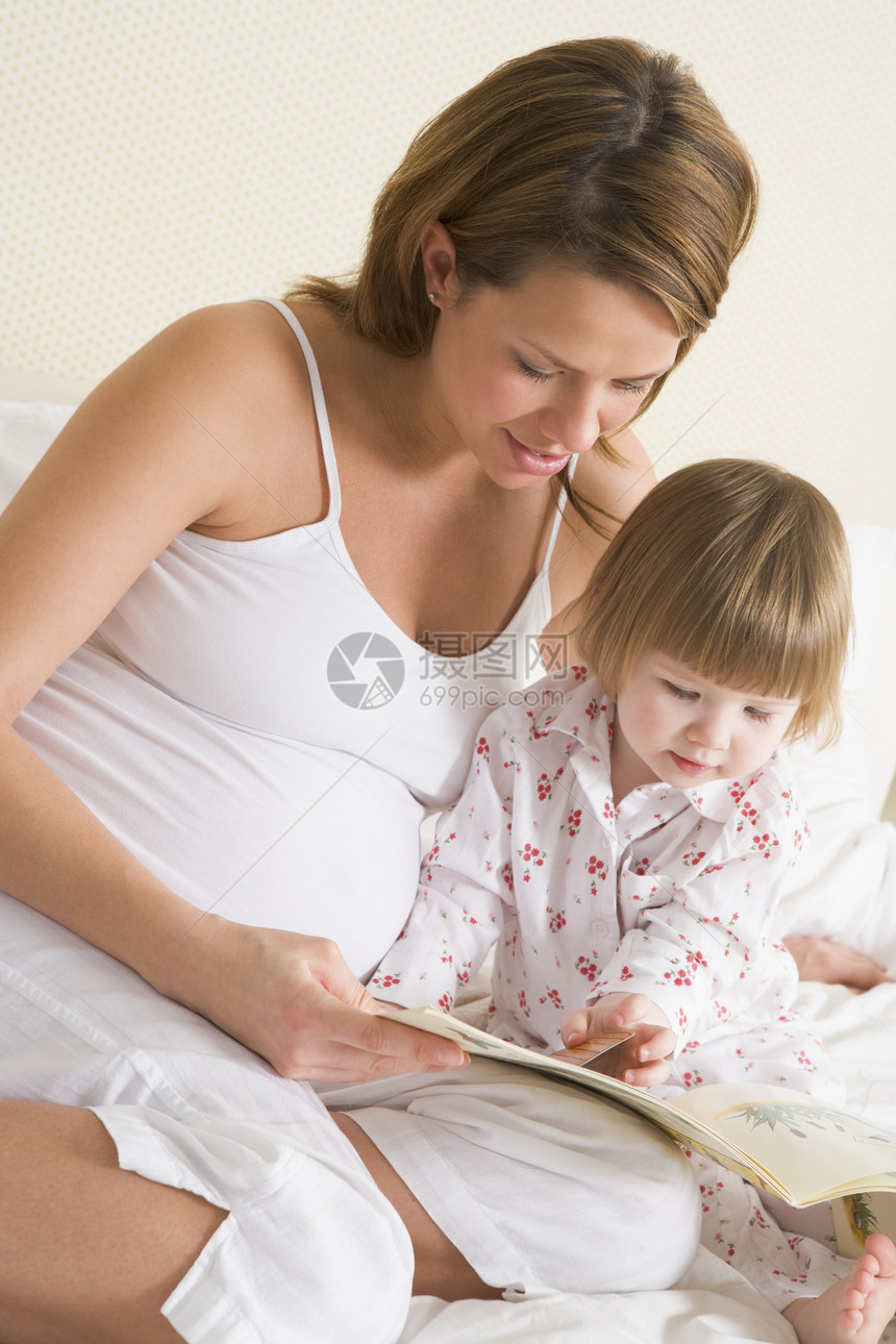 与女儿一起在卧室阅读书中的怀孕妇女就寝待产女子两个人女士孕产孕妇装家庭妈妈家长图片