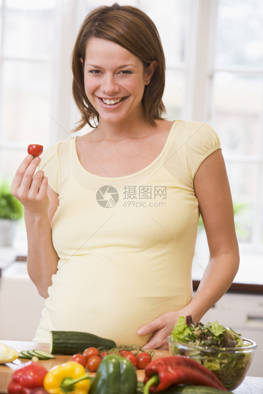 厨房的孕妇在笑着做沙拉孕妇装妈妈食物电视准妈妈女性蔬菜怀孕饮食孕产图片