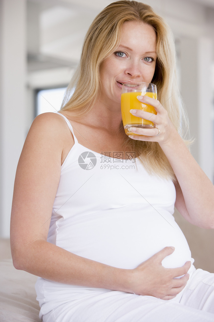 带橙汁杯子的孕妇家庭饮食相机待产享受怀孕孕妇装准妈妈新妈妈女性图片