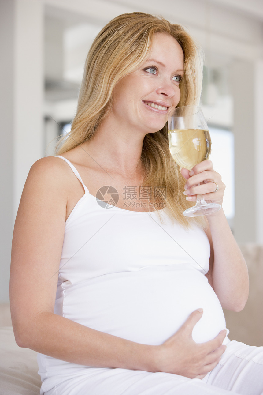 带着白酒杯的孕妇微笑着妈妈家长待产怀孕风险新妈妈准妈妈孕产一杯酒孕妇装图片