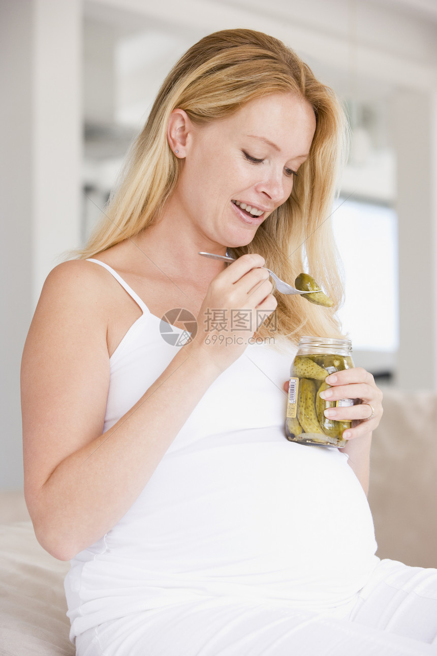怀着泡菜的孕妇微笑着享受孕妇装饮食新妈妈家长准妈妈家庭孕产妈妈待产图片