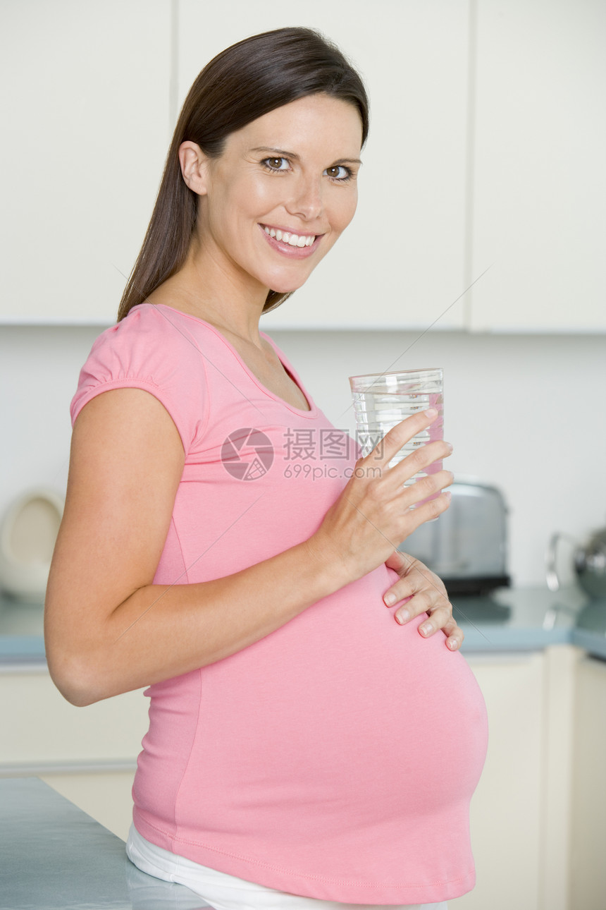 在厨房的孕妇 带着一杯水笑着准妈妈孕产女性怀孕待产享受饮食相机脱水新妈妈图片