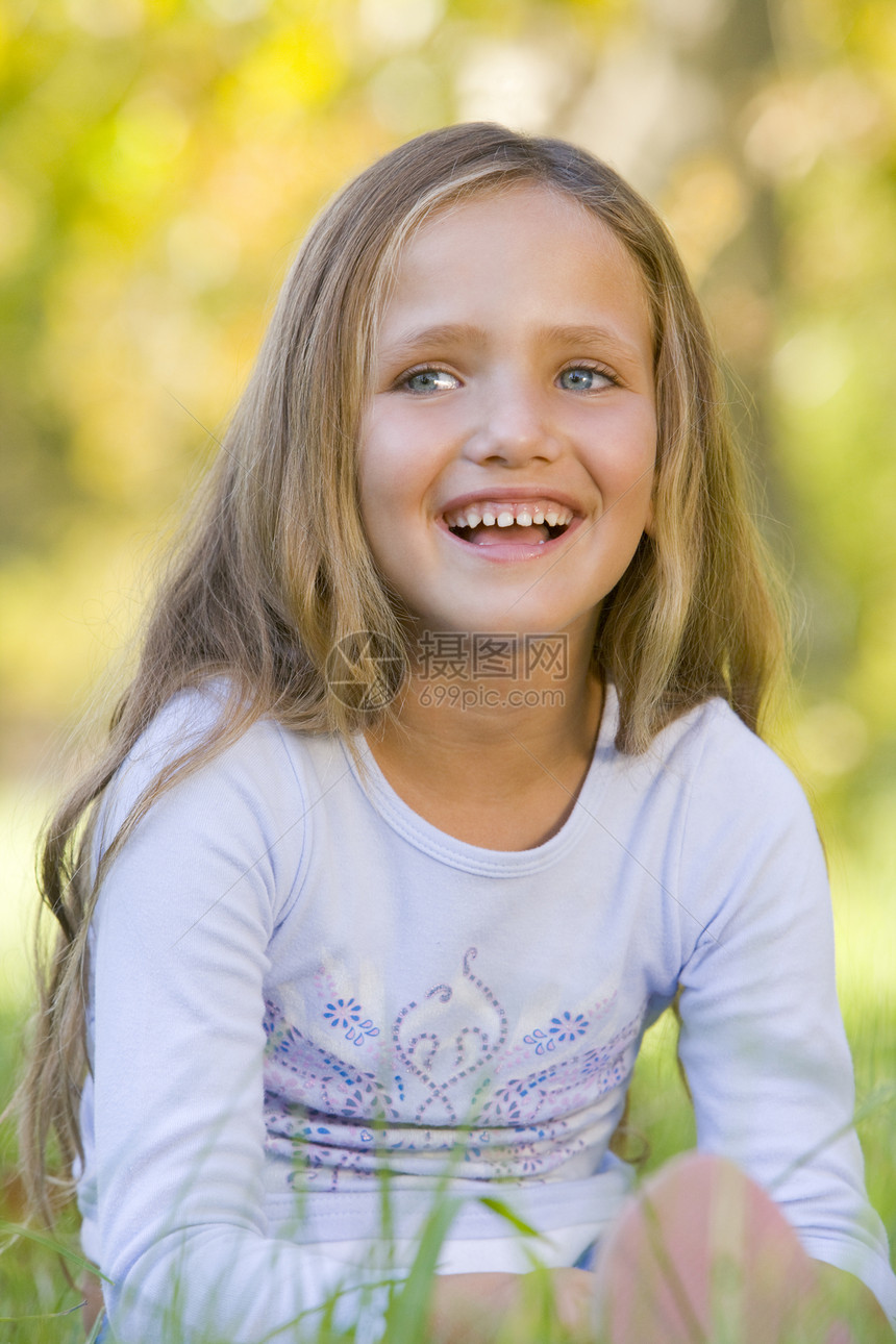 坐在户外微笑的年轻女孩孩子公园孩子们长度相机青春期农村情感女性图片