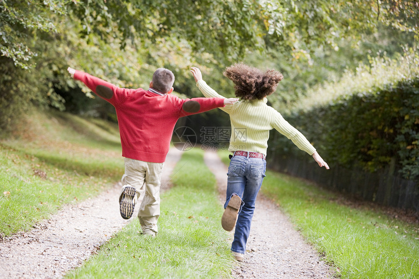 两个年轻朋友在户外的路上奔跑图片
