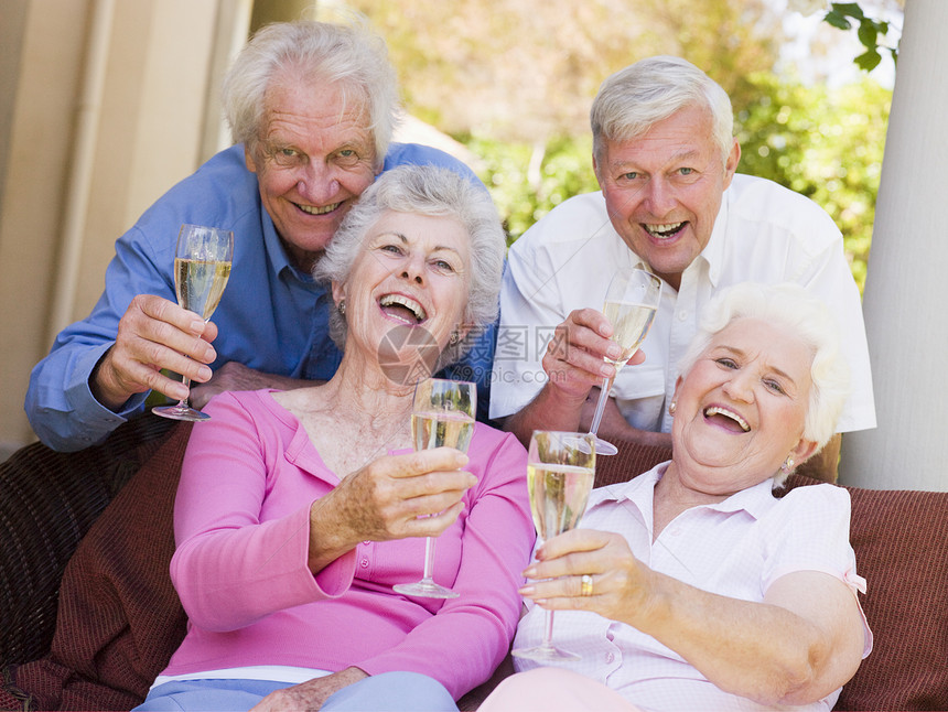 两对情侣在院子里 喝香槟和微笑乐趣周年纪念日女士情感四个人酒杯退休相机老年图片