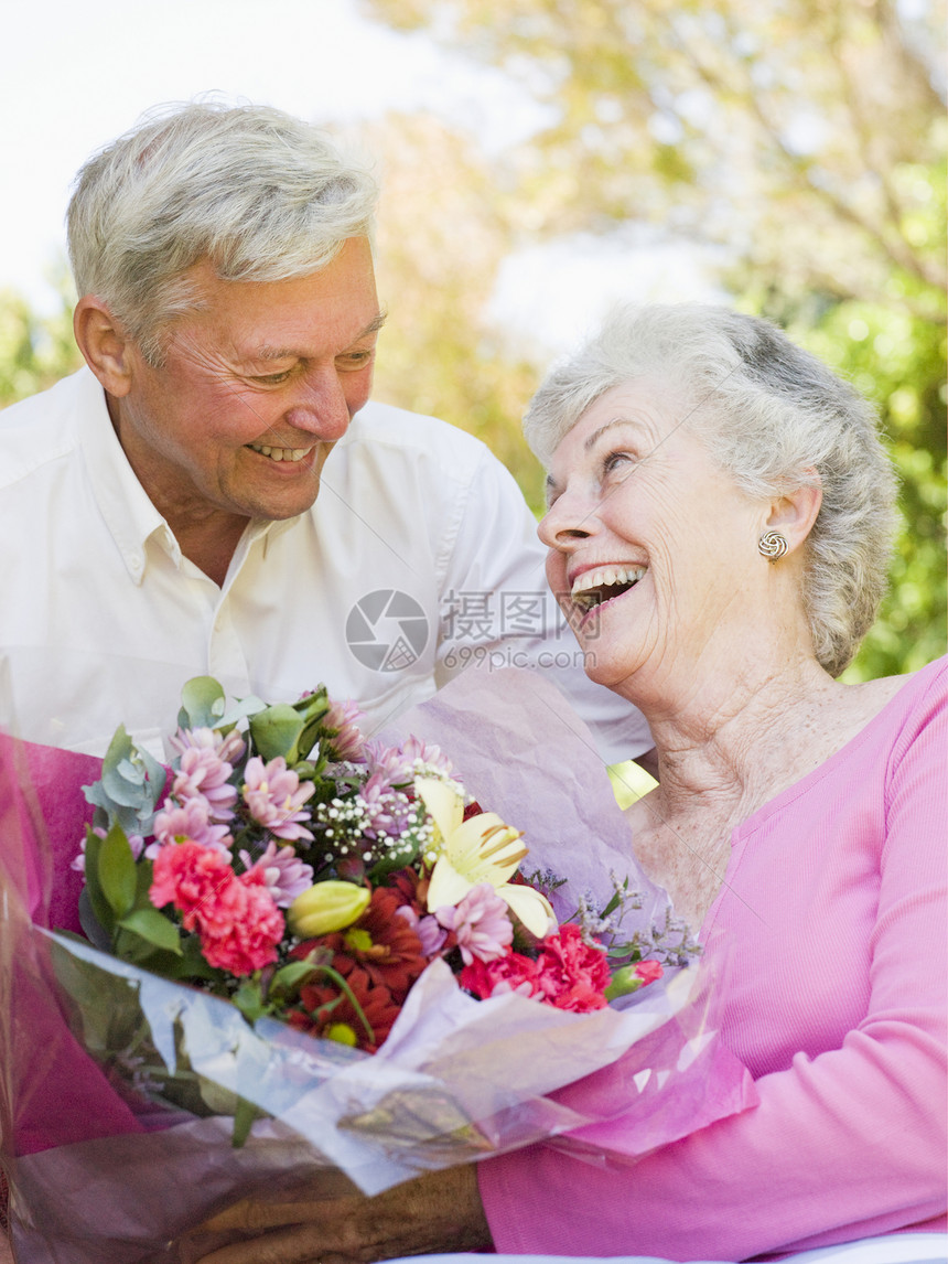 丈夫给妻子送花 在户外微笑图片