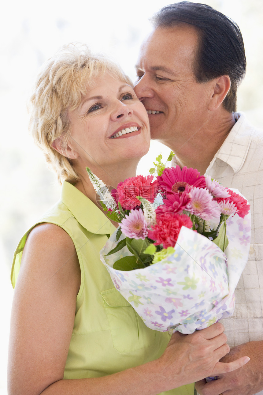 丈夫和妻子带着鲜花亲吻和微笑男人中年相机生日纪念日浪漫场合情感周年惊喜图片