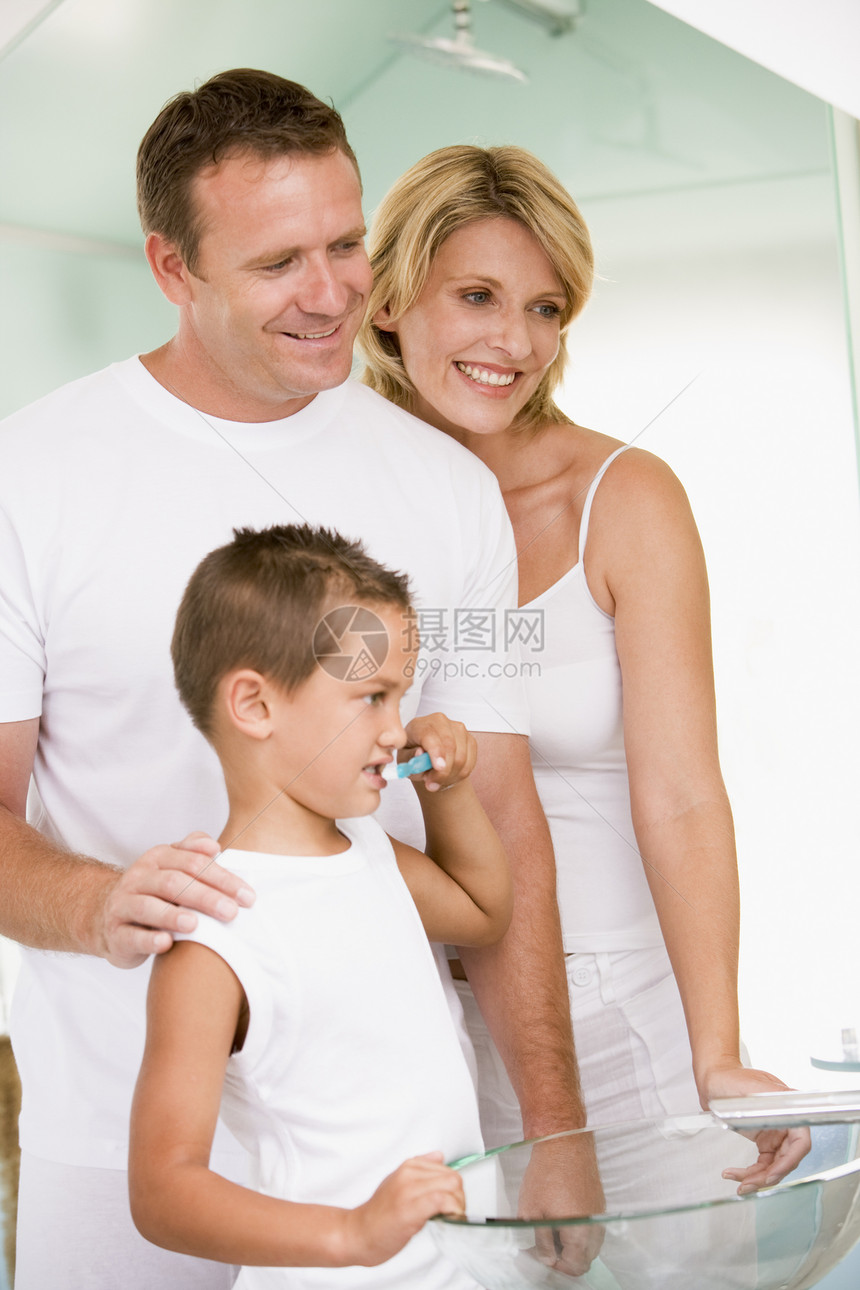在浴室的一对夫妇 年轻男孩刷牙母亲女士孩子们微笑爸爸男生睡衣妈妈父母父亲图片
