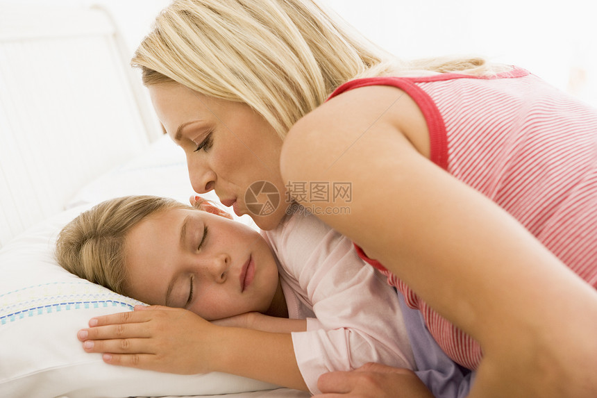 醒来的年轻女孩在床上亲吻图片