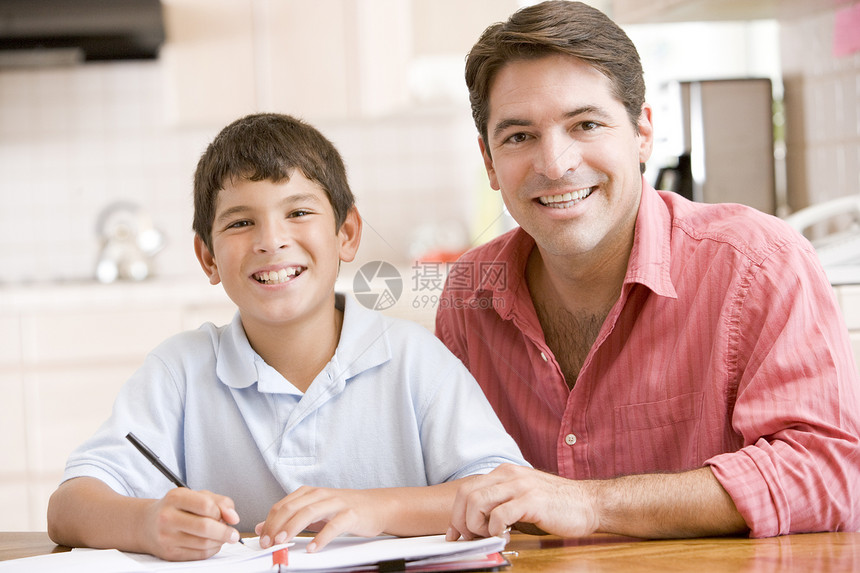 男人在厨房帮助小男孩做功课和微笑拉丁男生儿子写作项目男性孩子文件夹相机家庭作业图片