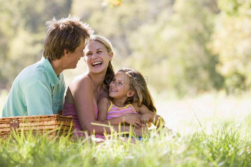 家庭在公园野餐和欢笑活动父亲孩子父母中年三个人篮子母亲微笑女士图片