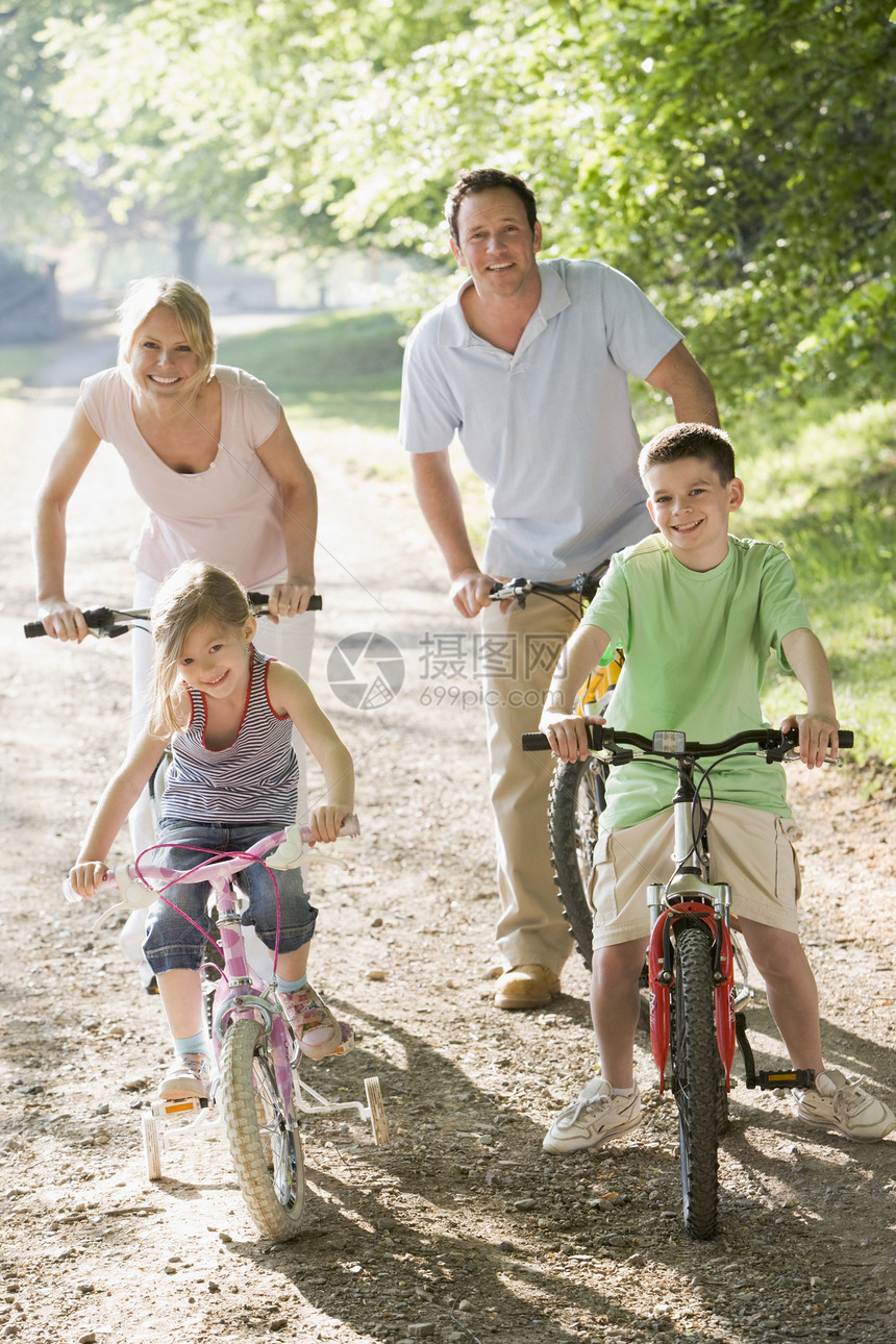 双脚骑自行车的家庭在路上微笑着笑图片