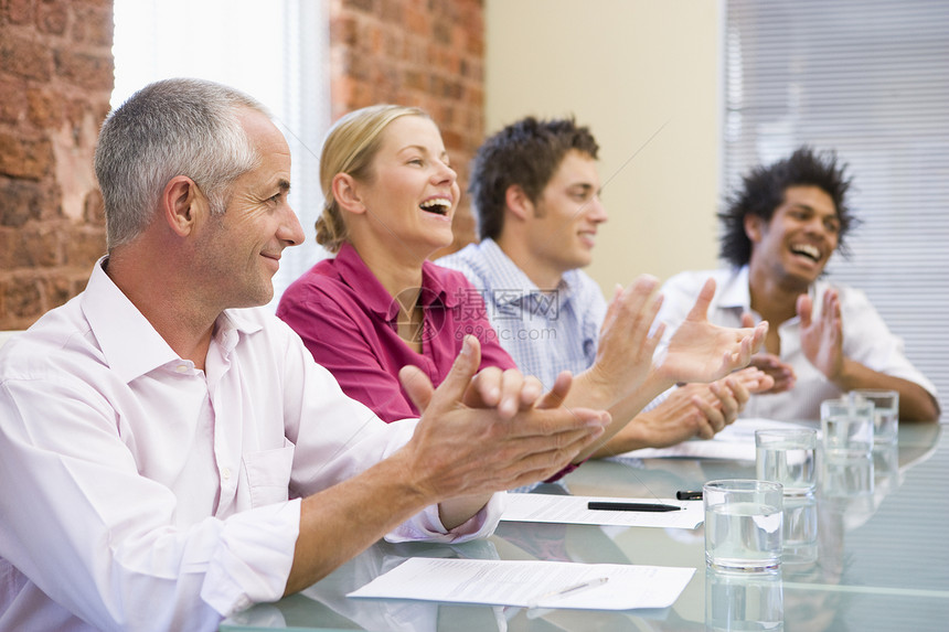 四位在会议室的商务人士 欢呼和微笑人士混血服饰办公室生意人雇员会议董事会相机商业图片
