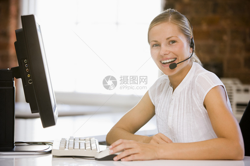 身戴头盔 坐在办公室微笑的女商务人士图片