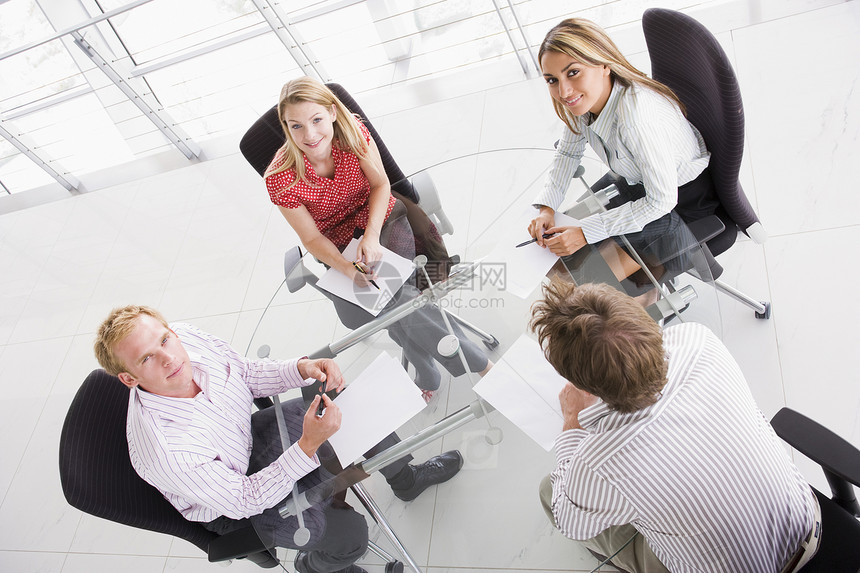 四位在会议室的商务人士 带着微笑着文件的笑容图片