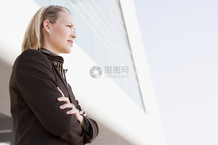 女商务人士通过建筑站在外面的户外手臂手势女性公司中年生意人视图时间女士低角度图片