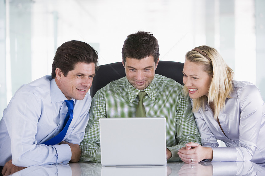 三名在办公室的商务人士带着笔记本电脑微笑图片
