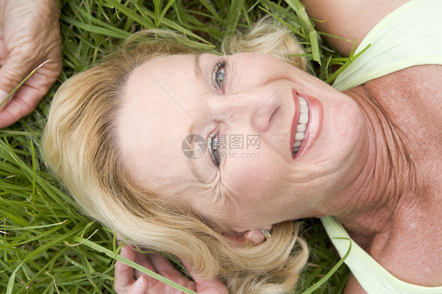 躺在草地上的女人微笑着退休水平女士高架女性农村图片