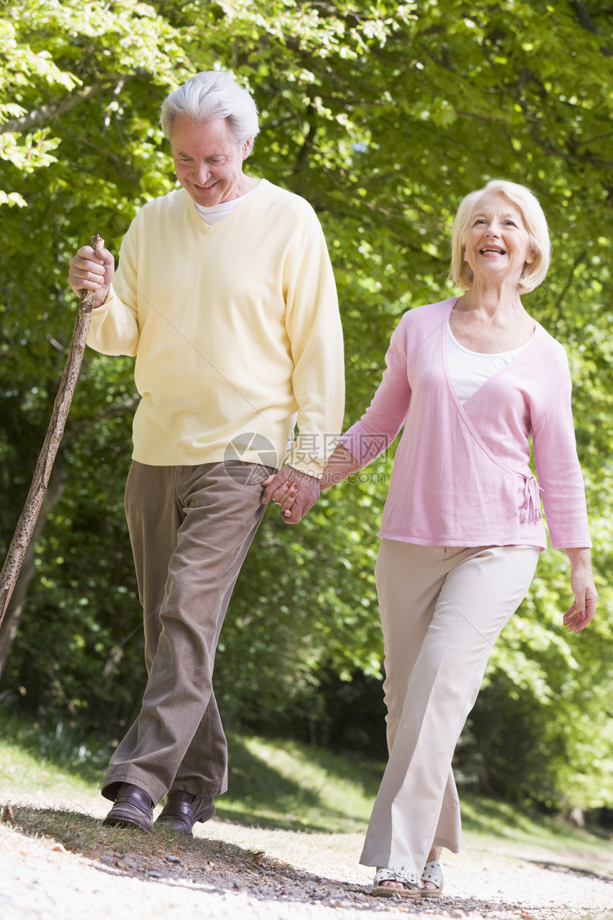 一对夫妇在公园的路上走着手牵手微笑女士林地享受夫妻森林妻子女性退休男性男人图片