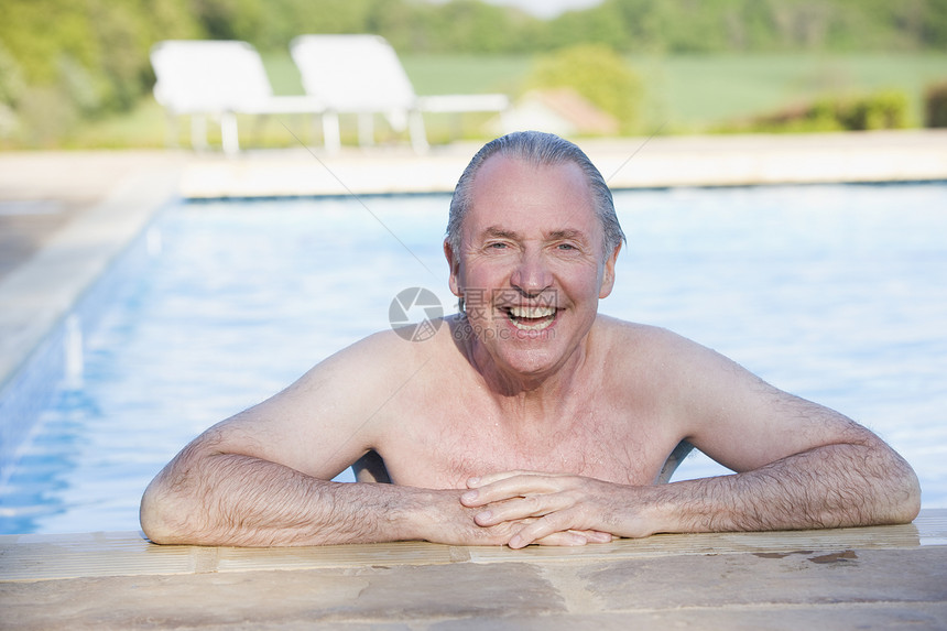 男人在户外游泳池中微笑图片