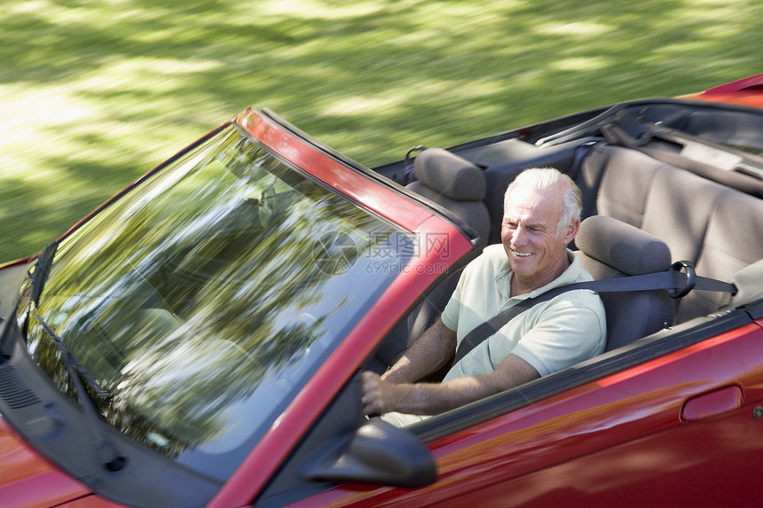 穿着可兑换汽车的男人微笑着享受运动男性退休摩托车敞篷车水平农村高架驾驶图片