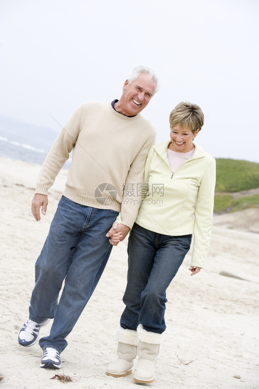 在海滩的情侣 握着手和微笑退休女士夫妻丈夫男人两个人男性女性妻子图片