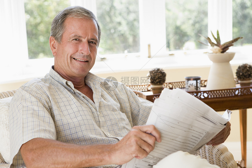男人在客厅看报纸笑着看报纸阅读长椅椅子男性水平微笑沙发长度相机休息室图片